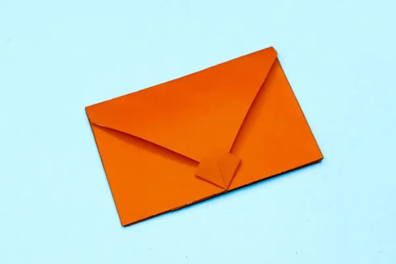 Bàn tay đang thực hiện gấp phong bì thư Origami, thể hiện lợi ích rèn luyện kỹ năng
